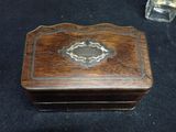 a small wooden box with a metal decoration on top of it