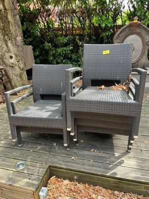 two chairs sitting on a wooden deck near a tree