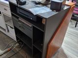 a desk with a laptop and a printer on it