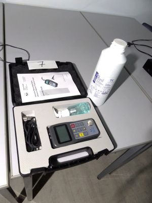 une boîte contenant une calculatrice et une bouteille d'eau, posée sur une table