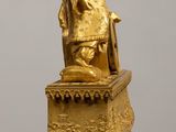 a gold statue of a woman sitting on top of a box