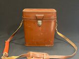 an image of a brown leather bag with a strap on it