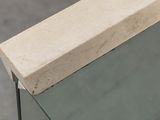 a close up of a glass table with a stone block on top