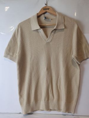 La chemise est suspendue à un cintre accroché au mur.