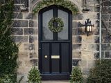 a black door with a wreath on the front of it