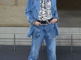 the woman is wearing a blue jacket and jeans and gold shoes