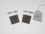 pair of black and silver cufflinks with a price tag