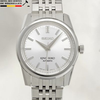 une montre en argent avec un cadran blanc et un bracelet en argent