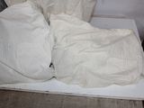 a white box with two pillows and a blanket on top of it