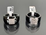 pair of black and white rings with diamonds on them sitting on a table