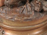 a bronze statue of a dog and a cat on a table