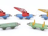four different types of toy trains on a white surface