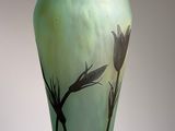 a glass vase with a flower on it on a table