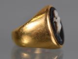 an image of a gold ring with a black stone in the center