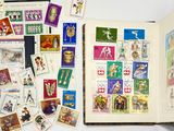 un livre ouvert sur lequel sont collés des timbres et dont les pages sont couvertes de timbres