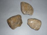 three pieces of rock sitting on top of a table next to each other