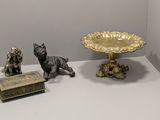 trois figurines posées sur une table, à côté d'un bol