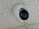 a white camera mounted on the ceiling of a building