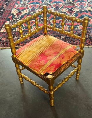 une chaise en bois sur laquelle est posé un coussin rouge
