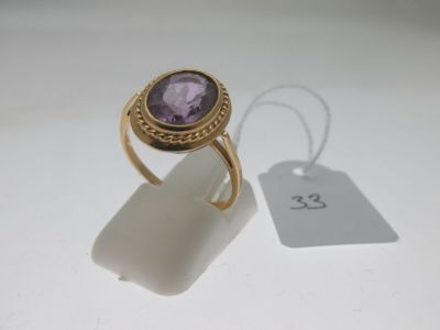 une image représentant une bague en or sertie d'une pierre violette