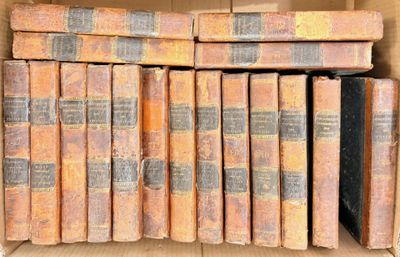 many old books in a cardboard box on the shelf