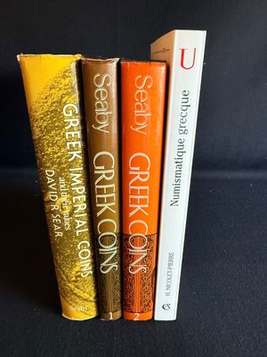 trois livres sont empilés les uns sur les autres sur une surface noire