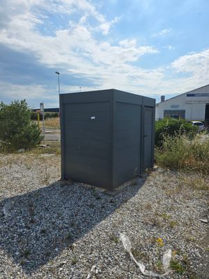 une petite boîte noire posée au milieu d'un champ de gravier