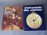 deux livres posés sur une table sur laquelle se trouve une horloge