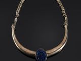 un collier en or et lapis-lazuli orné d'une perle de verre bleue