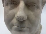 a white bust of a man with curly hair