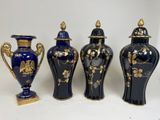 three blue vases with gold designs are lined up on a white surface