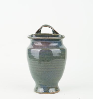 a blue vase with a handle on a white background