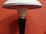 une photo d'une lampe de table posée sur une surface rouge