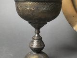 a silver bowl and a silver plate on a table