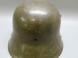 an old army helmet is sitting on a white surface