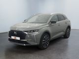 une voiture grise garée dans une pièce aux murs blancs
