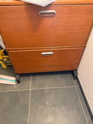 une photo d'une commode dans une salle de bains, sur laquelle se trouvent des feuilles de papier