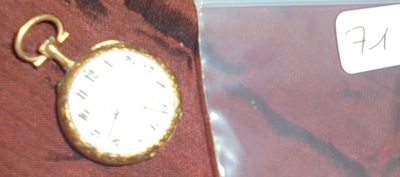 une montre de poche posée sur un tissu marron