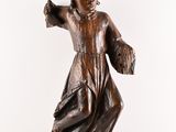 statue of a woman in a brown dress with her arms outstretched