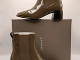 un gros plan sur une paire de bottines marron posées sur une boîte
