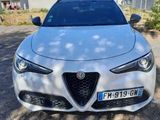 a white alfa car parked in front of a house