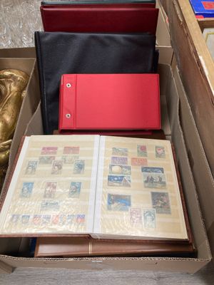 une boîte de timbres et un livre posés par terre