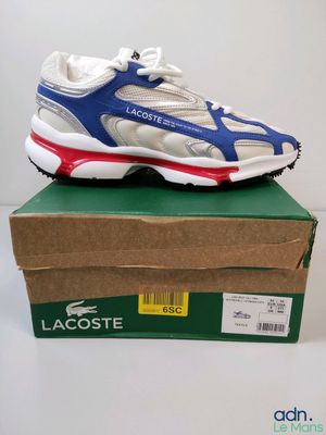 une paire de baskets Lacoste posée sur une boîte