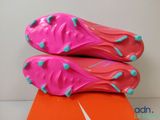 a pair of pink soccer shoes sitting on top of an orange box