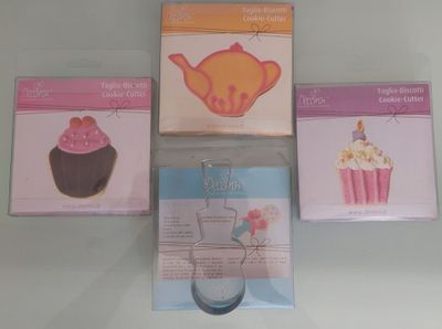three boxes of cupcakes and a cookie cutter on a table