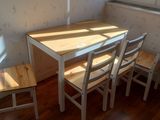 a small table and four chairs in the corner of the room