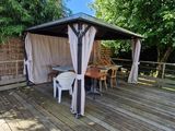 a gazebo on a deck with chairs and tables