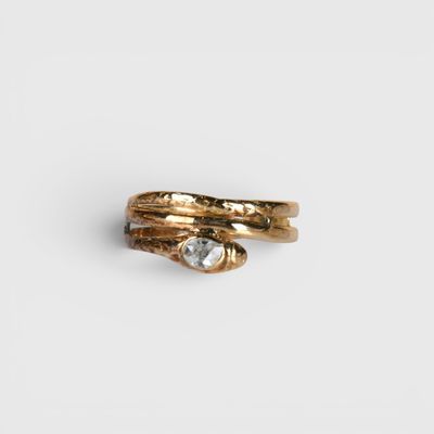 un gros plan d'une bague en or sertie d'une pierre transparente