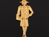 a close up of a gold pendant with a man holding a guitar