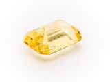 a yellow sapphire stone on a white background